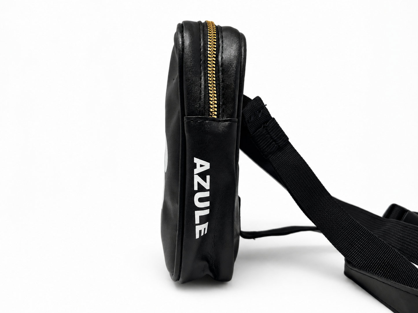 A black leather crossbody bag with a gold zipper and white 'AZULE' branding on the side, shown next to its black adjustable strap against a white background.